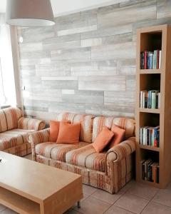 a living room with two couches and a brick wall at Feeling Home in Thessaloniki