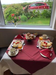 een tafel met een rode tafeldoek met eten erop bij Lahinch View in Doolin