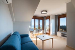 Una sala de estar con un sofá azul y una mesa. en MA Maisons & Apartments Portonovo, en Portonovo