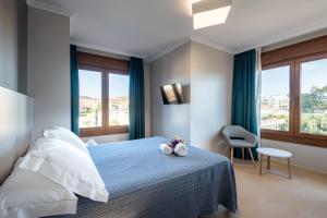 Un dormitorio con una cama con una colcha azul. en MA Maisons & Apartments Portonovo, en Portonovo