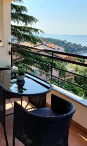 a table and chairs on a balcony with a view at Casa Panorama Studio in Rabac