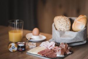 una mesa con una bandeja de pan y huevos y un vaso de zumo de naranja en AhriaNova, en Sand in Taufers