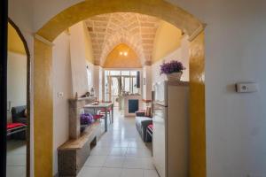 a hallway with an archway in a house with a refrigerator at Casa Amata Salentina in Squinzano