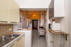 uma cozinha com armários brancos e um lavatório em Casa Amata Salentina em Squinzano