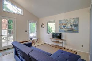 a living room with a blue couch and a tv at Agapios Cottage in Santa Barbara