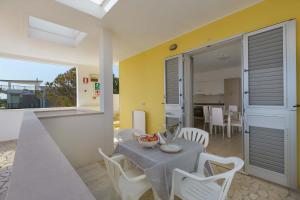 een keuken en eetkamer met een tafel en stoelen bij Residence Solaris in San Foca