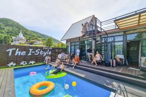 a group of people playing in a swimming pool at The I-style pool villa in Ban Tao Than