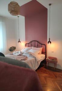 ボローニャにあるCasa Tulù B&Bのピンクの壁のベッドルーム1室(大型ベッド1台付)