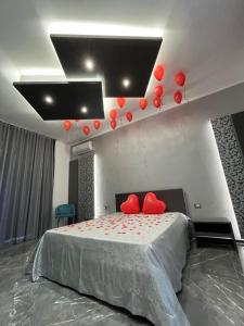 1 dormitorio con 1 cama con globos rojos en el techo en Samanà Superior Room, en Punta Prosciutto