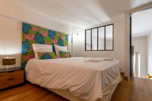 a bedroom with a large bed with a colorful headboard at "L' Atelier de la Tour" - Centre Ville - Confort - Cosy -Relax in Dijon