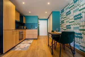 a kitchen with a table and a blue wall at "L' Atelier de la Tour" - Centre Ville - Confort - Cosy -Relax in Dijon +21 photos