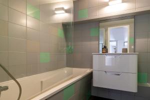 a bathroom with a tub and a sink and a mirror at "L' Atelier de la Tour" - Centre Ville - Confort - Cosy -Relax in Dijon