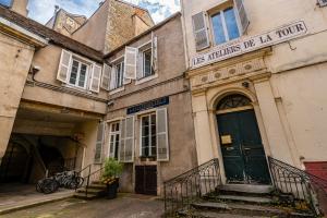 an old building with a green door on a street at "L' Atelier de la Tour" - Centre Ville - Confort - Cosy -Relax in Dijon