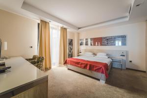 a hotel room with a bed and a desk at Hotel & Apartments HEC Residence in Sveti Stefan