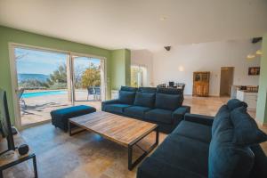 a living room with a couch and a table at LE PETIT CHENE in Apt