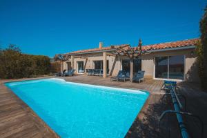 a villa with a swimming pool in front of a house at LE PETIT CHENE in Apt