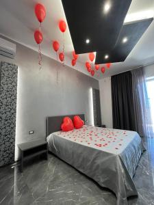 una camera da letto con palloncini rossi appesi al soffitto di Samanà Superior Room a Punta Prosciutto