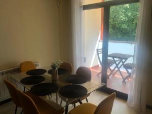 een eetkamer met een tafel en stoelen en een raam bij Apartamento MIRABOSQUE - plaza garaje incluida in Arenas de San Pedro