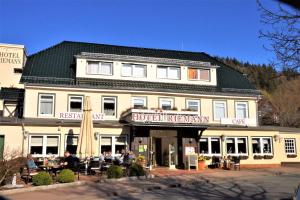 a large white building with people sitting outside of it at Hotel Riemann in Bad Lauterberg