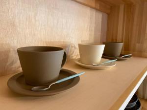 tres tazas de café y platillos en una mesa en FamB en Nakafurano