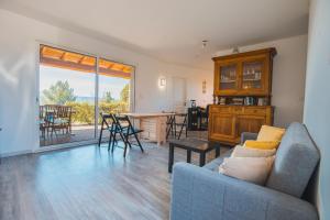 a living room with a couch and a table with chairs at LE PETIT CHENE in Apt