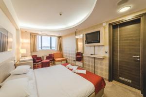 a hotel room with two beds and a television at Hotel & Apartments HEC Residence in Sveti Stefan