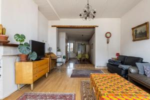 a living room with a couch and a tv at Factory of sweetness in Tienen