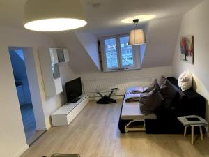 uma sala de estar com um sofá preto e uma televisão em Appartement-Koblenz em Koblenz