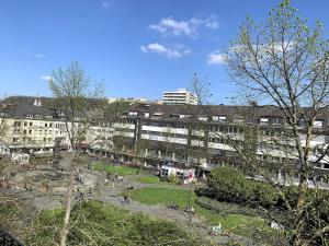 un parc en face d'un grand bâtiment avec des personnes dans l'établissement Appartement-Koblenz, à Coblence