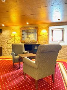 ein Wohnzimmer mit zwei Stühlen und einem Tisch in der Unterkunft Hotel Pazo de Lestrove by Pousadas de Compostela in Padrón