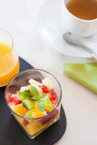 a bowl of fruit on a table with a cup of coffee at La Villa des Forges in Legé +15 photos