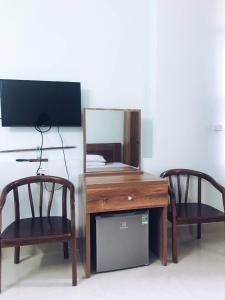 a desk with two chairs and a mirror on a table at Hoang Long Hotel Bai Chay in Ha Long