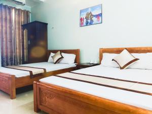 two beds in a room with two at Hoang Long Hotel Bai Chay in Ha Long
