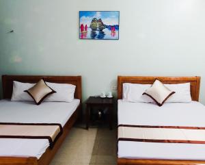 a room with two beds and a picture on the wall at Hoang Long Hotel Bai Chay in Ha Long