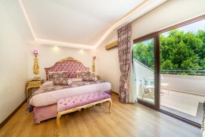 a bedroom with a pink bed and a balcony at Sundia By Liberty Oludeniz in Oludeniz +37 photos