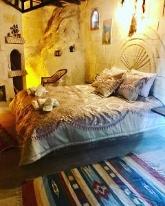 a bedroom with a bed in a stone room at Cappadocia Alaz Cave Otel in Nevşehir