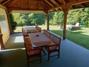 porche con mesa, sillas y columpio en Holiday home "Aida", en Visoko