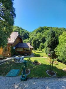 a log cabin with a playground in the yard at Holiday home "Aida" in Visoko