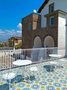 eine Terrasse mit Tischen und Stühlen vor einem Gebäude in der Unterkunft Villa Pia - suites in Castellammare di Stabia