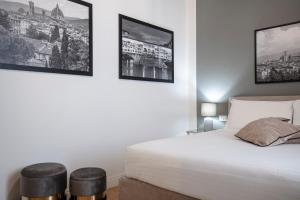 um quarto com uma cama e duas fotografias na parede em San Niccolò Luxury Apartment em Florença