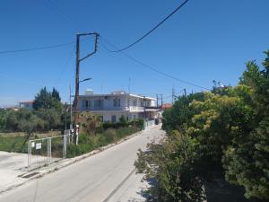 eine leere Straße mit einem weißen Haus auf einem Hügel in der Unterkunft Sweet house 64B in Vrachati