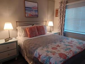 um quarto com uma cama, 2 candeeiros e uma janela em Tropic Terrace #49 - Beachfront Rental condo em St. Pete Beach