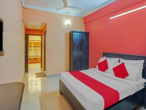 a bedroom with a bed with a red wall at Marhaba tourist home in Kozhikode