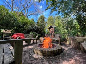 a fire pit in a park with two benches at The Annexe at Yew Tree House in Canterbury