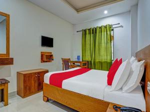 a bedroom with a large bed with red pillows at Marhaba tourist home in Kozhikode