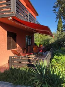 a house with a deck with chairs and a table at Holiday Home Andreja in Malinska