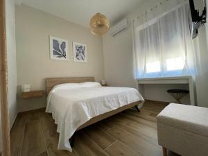 a bedroom with a white bed and a window at MohalaB&B in Bacoli