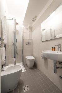 ein Badezimmer mit einer Badewanne, einem Waschbecken und einem WC in der Unterkunft Hotel La Vela in Passignano sul Trasimeno