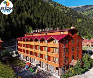 Un hôtel avec des montagnes en arrière-plan dans l'établissement Sezgin Hotel, à Uzungöl