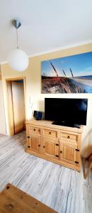 a living room with a flat screen tv on a wooden entertainment center at Caroline & Maurice in Ostseebad Koserow